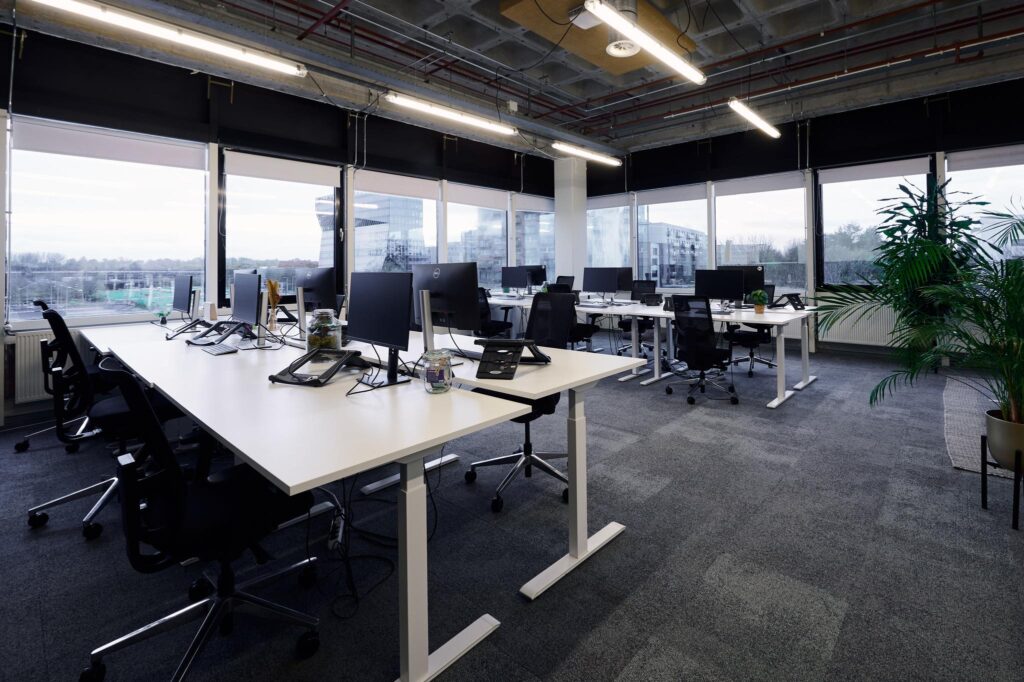 Moderne open kantoorruimte aan de Johan Huizingalaan met werkplekken, computers en uitzicht op omliggende gebouwen.